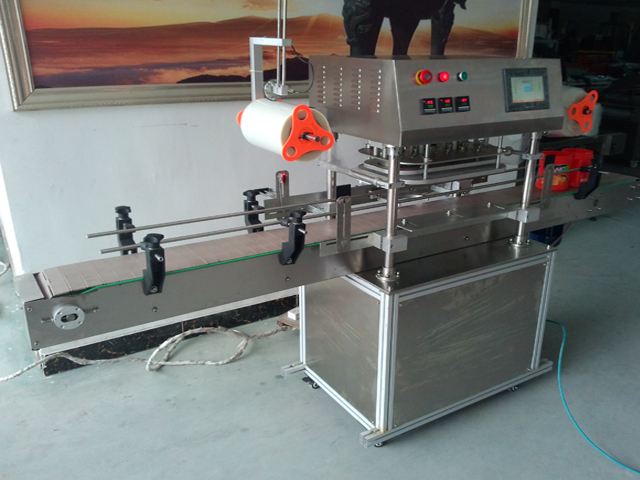 side pictures for automatic jars sealing machine מכונת איטום בפעולה.jpg